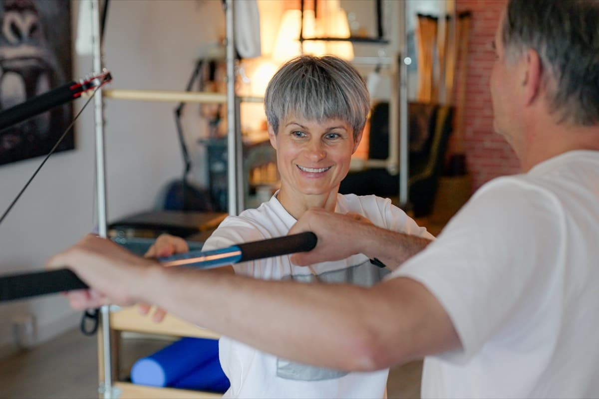Aleksandra guide un client sur un exercice de barre au studio Momentum